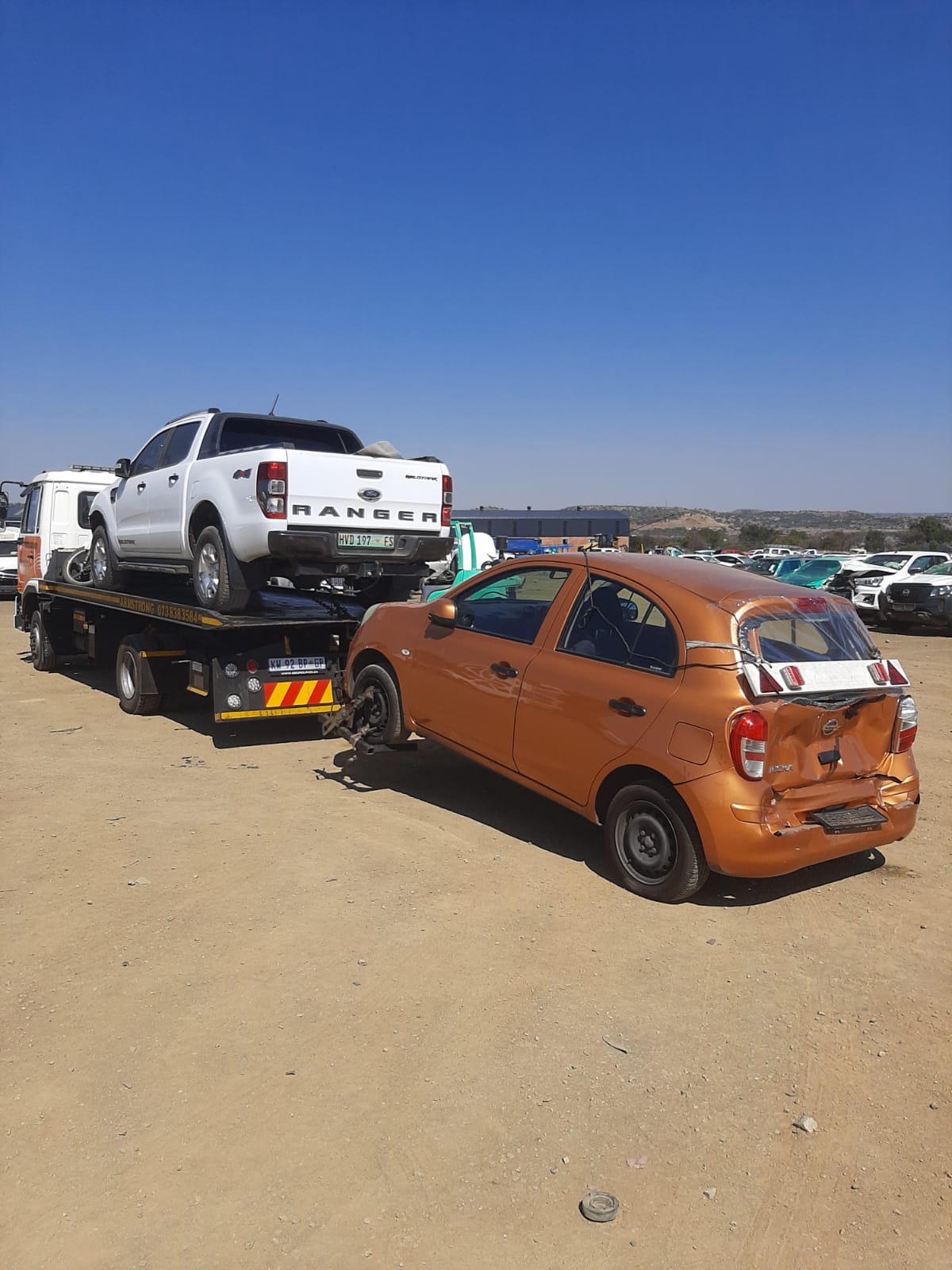 Ford Ranger bakkie loaded on the Armstrong flatbed with a damaged Nissan Micra alongside